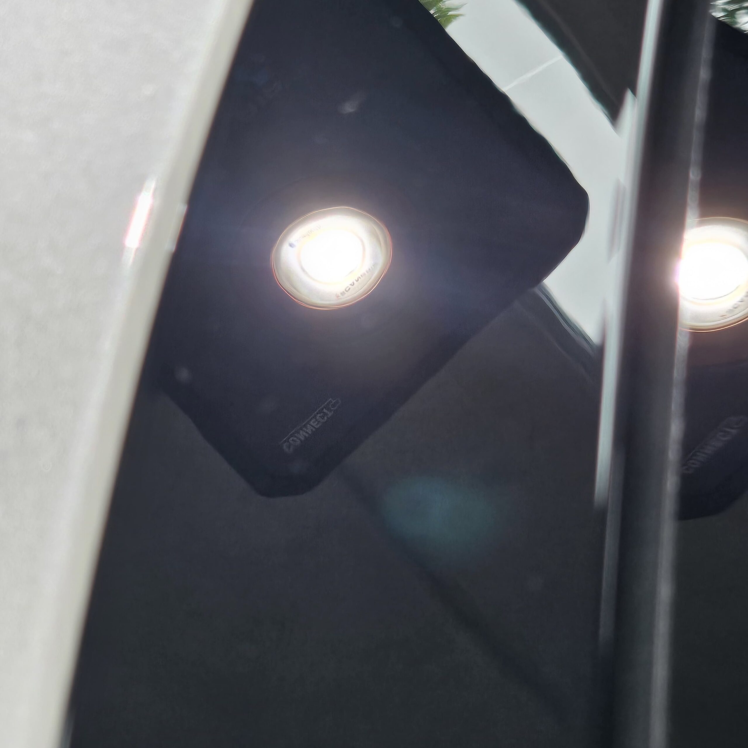 Black car paint under Scangrip inspection light revealing heavy swirl marks and scratches before paint correction at JETWASH Coolum Beach